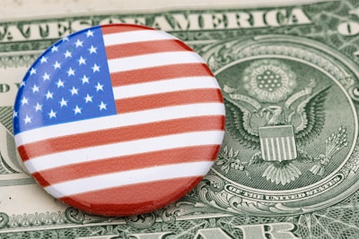 a button with the american flag on top of a dollar bill